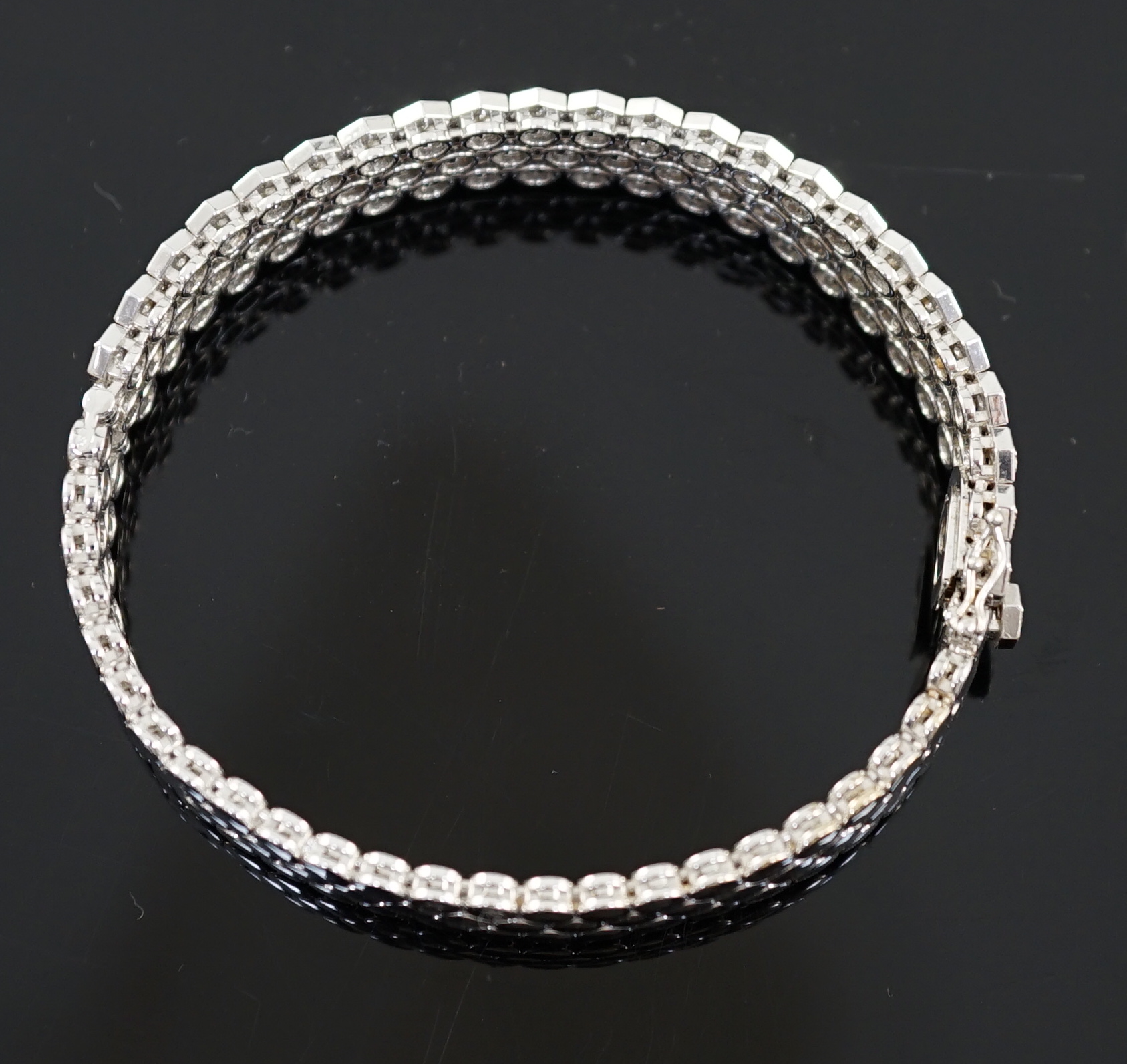 A modern 18ct white gold and diamond cluster set hinged bangle